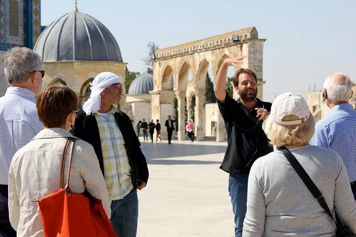 Two guides speaking to a small group in the Jerusalem Old City on a dual narrative Jerusalem Old City tour